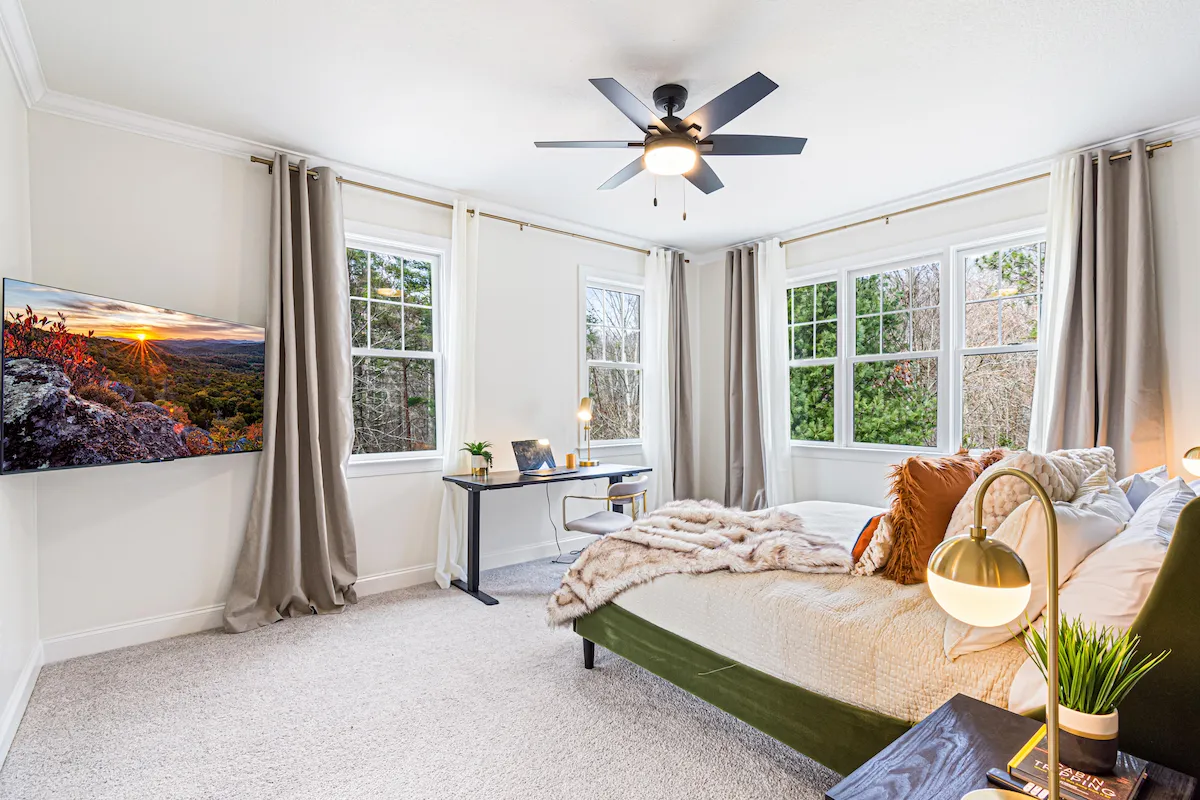 Primary suite with king bed sit-stand desk and en-suite bath